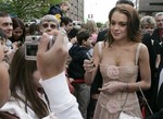 Actress Lindsay Lohan poses for a fan as she arrives at the Fitzgerald Theater Wednesday, May 3, 2006 in St. Paul, Minn., for the world premiere of the movie "A Prairie Home Companion" which was filmed in St. Paul last summer.