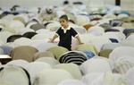 A child watch Saudi men praying at the Imam Turki bin Abdullah mosque during Eid al-Fitr morning prayers in Riyadh, Saudi Arabia, Tuesday, Sept. 30, 2008.