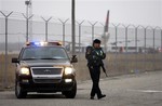 A law enforcement officer guards an entrance near the parked Northwest Airlines flight 253 plane, background, at the Detroit Metropolitan Airport in Romulus, Mich., Sunday, Dec. 27, 2009.