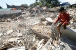 Yose Andre, 34, grieves for his missing cousin in the rubble on Friday, Oct. 2, 2009 in Padang, Indonesia. Two days after Wednesday's 7.6-magnitude quake that toppled thousands of buildings on Sumatra island, stricken residents in a district north of the hard-hit city of Padang, had yet to receive help.