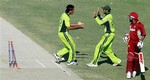 Pakistan's Abdul Razzaq, left, and Shoaib Malik celebrate dismissal of West Indies captain Brian Lara, right, in the second One Day International cricket match at Iqbal stadium in Faisalabad, Pakistan, Thursday, Dec. 7, 2006.