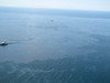 Response boats work to clean up oil where the Deepwater Horizon oilrig sank April 22, 2010.