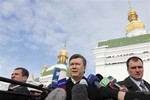 Ukrainian opposition leader and presidential candidate Viktor Yanukovych, center, speaks to the media outside the Kyiv-Pechersk Lavra church in Kiev, Ukraine, Saturday, Feb. 6, 2010.