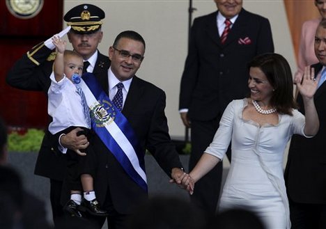 El Salvador's incoming President Mauricio Funes carries his son Gabriel as he walks with his wife Vanda Pignato after his swearing in ceremony in San Salvador Monday, June 1, 2009.