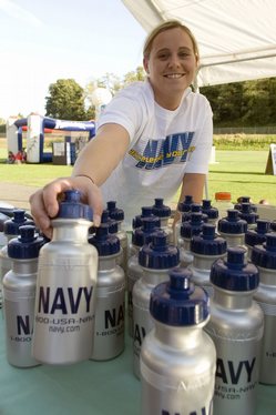 Hospitalman Karrie Cook Branch Medical Clinic, Naval Station Everett, organizes water bottles at the Navy booth prior to the start of the Aqua Sox baseball game.