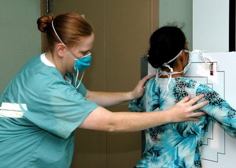 Navy Hospital Corpsman 1st Class Karri Wells of Antioch, Calif., positions a patient for an X-ray aboard the U.S. Military Sealift Command (MSC) Hospital ship USNS Mercy (T-AH 19).