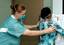 Navy Hospital Corpsman 1st Class Karri Wells of Antioch, Calif., positions a patient for an X-ray aboard the U.S. Military Sealift Command (MSC) Hospital ship USNS Mercy (T-AH 19).