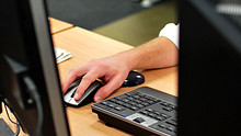 A hand rests on a computer mouse