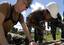 Steelworker 3rd Class Ben Hickok, with Naval Mobile Construction Battalion (NMCB) 7, stabilizes a two-by-four while a member of the Philippine Army 54th Engineering Brigade drills a hole while building a frame for a new school in Datu Andong.