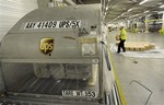 A worker loads a parcel at the UPS distribution center at the International Cargo Airport in Cologne, western Germany, Monday Nov. 1, 2010.