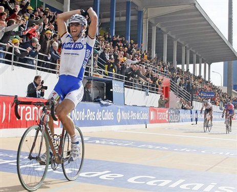 Belgium's Tom Boonen, left, of the Quick Step cycling team (Belgium) raises his arms as he crosses the finish line to win the classic cycling race Paris-Roubaix at the Roubaix cycling ring, Sunday, April 13, 2008.