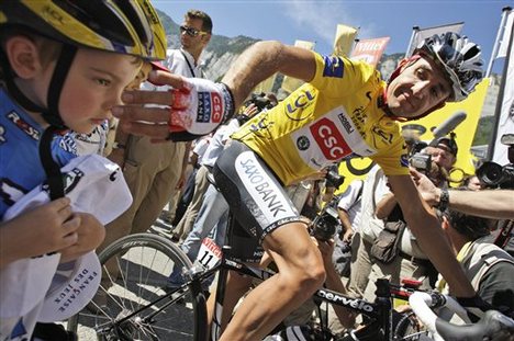 New overall leader Carlos Sastre of Spain greets a little cycling fan prior to the start of the 18t stage of the Tour de France cycling race