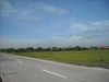 Concrete Road  -  Idle Land  -  Farmland  -  Cloudy Blue Skies  -  Climate  -  Good Weather Condition