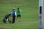 A golfer sways his club while his caddy looks at him in a Golf Club area located in Intramuros , Manila City , Philippines , March 8 , 2008.