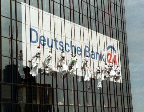 File - Climbers abseil down the front of the Deutsche Bank headquarters in Frankfurt, Germany to unveil the new Logo of the 