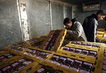 Hamas policemen check a shipment of strawberries before it moves to Israel from Gaza at the Kerem Shalom border crossing near Rafah in southern Gaza, Sunday, Nov. 28, 2010. Israel needs to do more to ease its blockade of Gaza and allow exports from the Hamas-ruled territory, international Mideast envoy Tony Blair said in an interview Sunday, after meeting with the Israeli and Palestinian prime ministers.