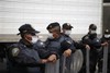 Mexico City police wearing face-masks guard a truck arriving with the bodies of some of the 72 migrants who were killed in northern Mexico while trying to reach the US border, at a funeral home in Mexico City, Wednesday Sept. 1, 2010.