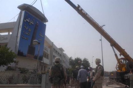 Iraqi engineers place a billboard depicting Mosul´s famous Al Hadra Minaret in front of the city hall building in Mosul, Iraq, July 16, 2003. DoD photo by Sgt. Michael Bracken, U.S. Army. (Released) (DOD Collections Photo) KLeo