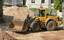 A loader is a heavy equipment machine (often used in construction) that is primarily used to 