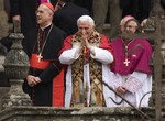 Pope Benedict XVI gestures to the cheering crowd on Obradoiro square that overlooks the Cathedral of Santiago de Compostela, background, in northern Spain, on Saturday, Nov. 6, 2010.