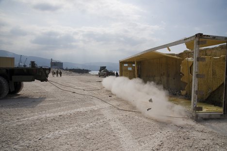 Sailors assigned to Amphibious Construction Battalion (ACB) 2, remove a container box blocking entry into their camp in Port-au-Prince, Haiti.