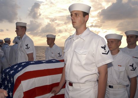 Sailors prepare to commit to the sea the body of Machinist's Mate 3rd Class Nathan Taylor during a Burial at Sea.