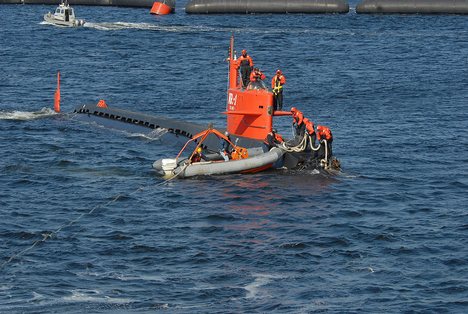 Sailors aboard nuclear research submarine NR-1 receive a towline and ball from Sailors on an SR-6 rigid hull inflatable boat .