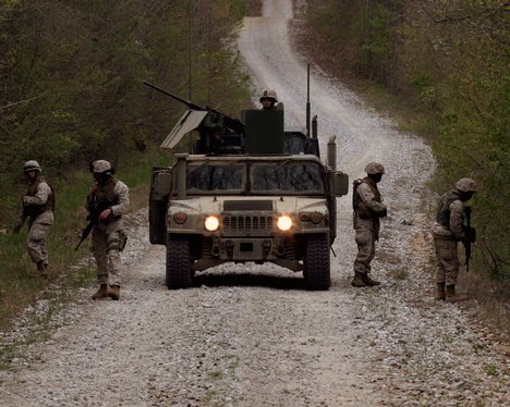 U.S. Marines and Navy sailors carefully comb the roadside for mock improvised explosive devices while training at Fort Pickett, Va., on April 18, 2007. The Marines and sailors of Combat Logistics Battalion 22 are training to search for IEDs as they prepa