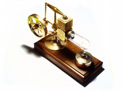 A desktop alpha Stirling engine. The working fluid in this engine is air. The hot heat exchange is the glass cylinder on the right, and the cold heat exchanger is the finned cylinder on the top