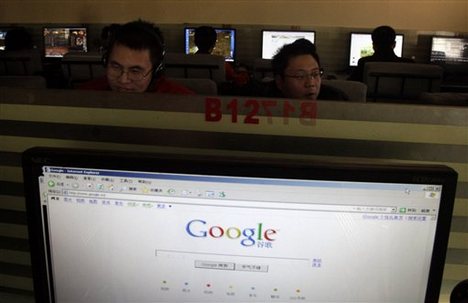 a Microsoft Internet Explorer browser displays the Google Web site as men work on computers in Beijing, China.