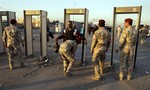 A Shiite pilgrim passes through a metal detector on the outskirts of Baghdad, Iraq, Saturday, Jan. 22, 2011, on his way to Karbala for Arbaeen.