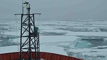 A view over the bow of the Aurora Australis as it approaches the Antarctic coastline.