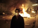 An anti-government protester is backdropped by a fire set up by protesters near the Tahrir Square, in downtown Cairo, Egypt, Friday, Jan. 28, 2011. Egyptian activists protested for a fourth day as social networking sites called for a mass rally in the capital Cairo after Friday prayers, keeping up the momentum of the country's largest anti-government protests in years.