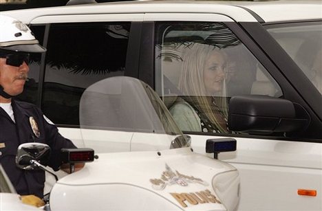 Britney Spears, sitting in the front left passenger seat, is driven away from Los Angeles County Superior court, escorted by Los Angeles Police officers, after a custody hearing Tuesday, May 6, 2008, in Los Angeles.