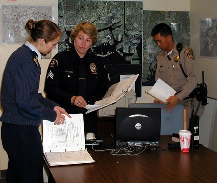 LOS ANGELES, Calif. (March 24, 2003)--Lt. j.g. Vanessa Martin of Marine Safety Office Los Angeles confers with Los Angeles Port Police Sgt. Rosa Reynoso while California Highway Patrol Officer James Ragle observes in the Joint Operation Center in Los Angeles. The Coast Guard along with Customs, Immigration and Naturalization Service, Los Angeles County Sheriff's Office, Port Police, Los Angeles Police Department, Los Angeles Fire Department and California Department opened the Joint Operation Ce