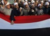 Clerics from Al Azhar Islamic university, some holding their identity cards, chant anti-government slogans during a protest in Tahrir, or Liberation, Square in Cairo, Egypt, Monday Jan. 31, 2011. A coalition of opposition groups called for a million people to take to Cairo's streets Tuesday to ratchet up pressure for President Hosni Mubarak to leave.