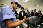 Swiss President Doris Leuthard, center, looks at a Chinese worker at production line at the factory of Lenovo Electronic Technology Co., Ltd. Wednesday, Aug. 11, 2010 in Shanghai. Leuthard travels China on an Economic Mission.