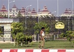 A local man walks past the fence outside the parliament building in Naypyitaw, Myanmar, Sunday, Jan. 30, 2011. Myanmar  is preparing to open its first session of parliament Monday in more than two decades, a major step in the ruling military's self-styled transition to democracy but one being carried out with little fanfare or public enthusiasm.