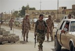 In this Monday, Oct. 6, 2010 photo, armed Sunni militiamen work at a checkpoint in Samarra, 60 miles (95 kilometers) north of Baghdad, Iraq. The men are part of Samarra's  Sahwa _ Arabic for Awakening, or commonly known as the Sons of Iraq, who are former Sunni insurgents now allied with U.S. and Iraqi security forces to provide security in the northern city.