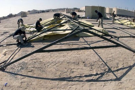 Members of the 355th AEG (Air Expeditionary Group) attach interior linings to the frame of a TEMPER (Tent Extendable Modular Personnel) tent at Masirah Air Base, Oman. The tents will be shelters for incoming troops deployed in support of Operation ENDURIN