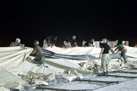 Members of the 366th Civil Engineering Squadron work as a team on a TEMPER (Tent, Extendable, Modular, Personnel) tent, setting it up as a new dining facility tent outside of tent-city while deployed at an undisclosed location during Operation ENDURING FR