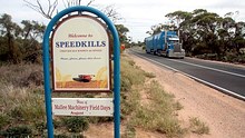 A truck passes be a new speed kills sign on the outskirts of a town in Victoria