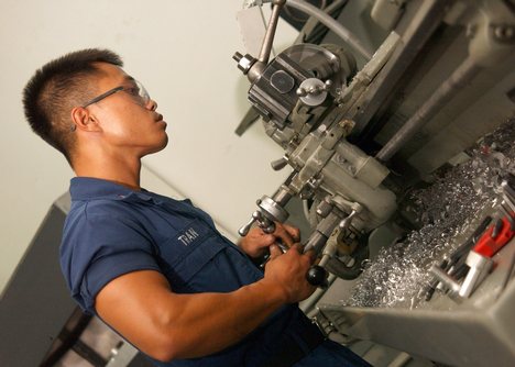 Aviation Structural Mechanic 2nd Class Thanh T. Tran, of Corpus Christi, Texas, uses a lathe to machine.