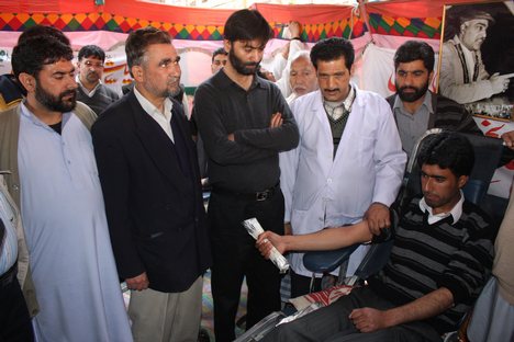 Jammu and Kashmir Liberation Front Chairman Mohammad Yasin Malik looks as a JLKLF party supporter donate blood at a camp organized by the Jammu and Kashmir Liberation Front (JKLF) on the death anniversary of one of its founding members, Dr. Abdul Ahad Guroo