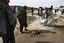 Afghan men looks at the blood stained clothing after a explosion in Spin Boldak district of Kandahar, south of Kabul, Afghanistan, Thursday, Feb, 24, 2011. A suicide bomber blew himself up Thursday in southern Afghanistan, killing one Afghan intelligence service officer and wounding more than two dozen other people.