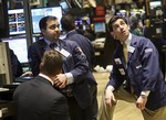 Dilip Patel, left and Peter Mazza, right, watch their monitors as they work the trading floor of the New York Stock Exchange