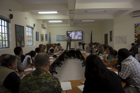 Service members from nations around the world, along with representatives from the United States Agency for International Development (USAID) and World Food Program (WFP), gather at the United Nations headquarters in Haiti.