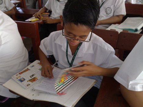 A student writing his lesson in the class. - Philippines