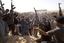 Libyan gunmen from the forces against Libyan leader Moammar Gadhafi fire in the air during a mass funeral for rebel gunmen killed in fighting in Ajdabiya, eastern Libya, Thursday, March 3, 2011.