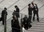 Office workers in Tokyo's Shiodome district near Tokyo Bay stay on the pedestrian deck, observing surrounding high-rise office and hotel buildings swaying Friday, March 11, 2011, shortly after a 7.9-magnitude earthquake has struck off Japan's northeastern coast.